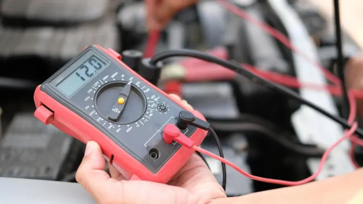 Digital multimeter measuring battery pack voltage during load testing